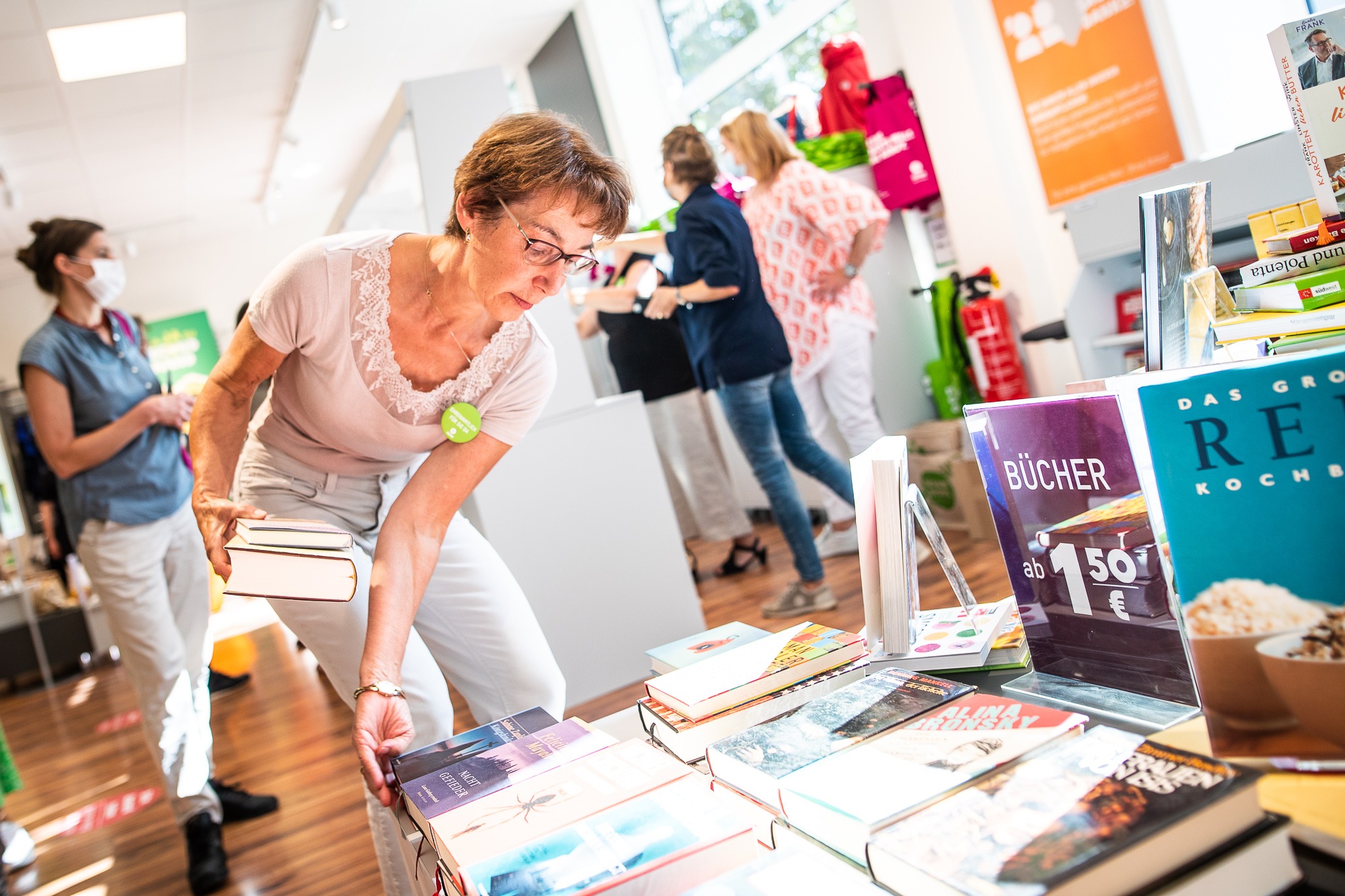 Das Foto zeigt eine Mitarbeiterin in einem Ladengeschäft ders Vereins Oxfam Deutschland, wie sie Bücher auf eine Auslage stapelt. Das Foto habe ich im Rahmen der Eröffnung des Geschäfts in Berlin Weissensee für Oxfam fotografiert.
